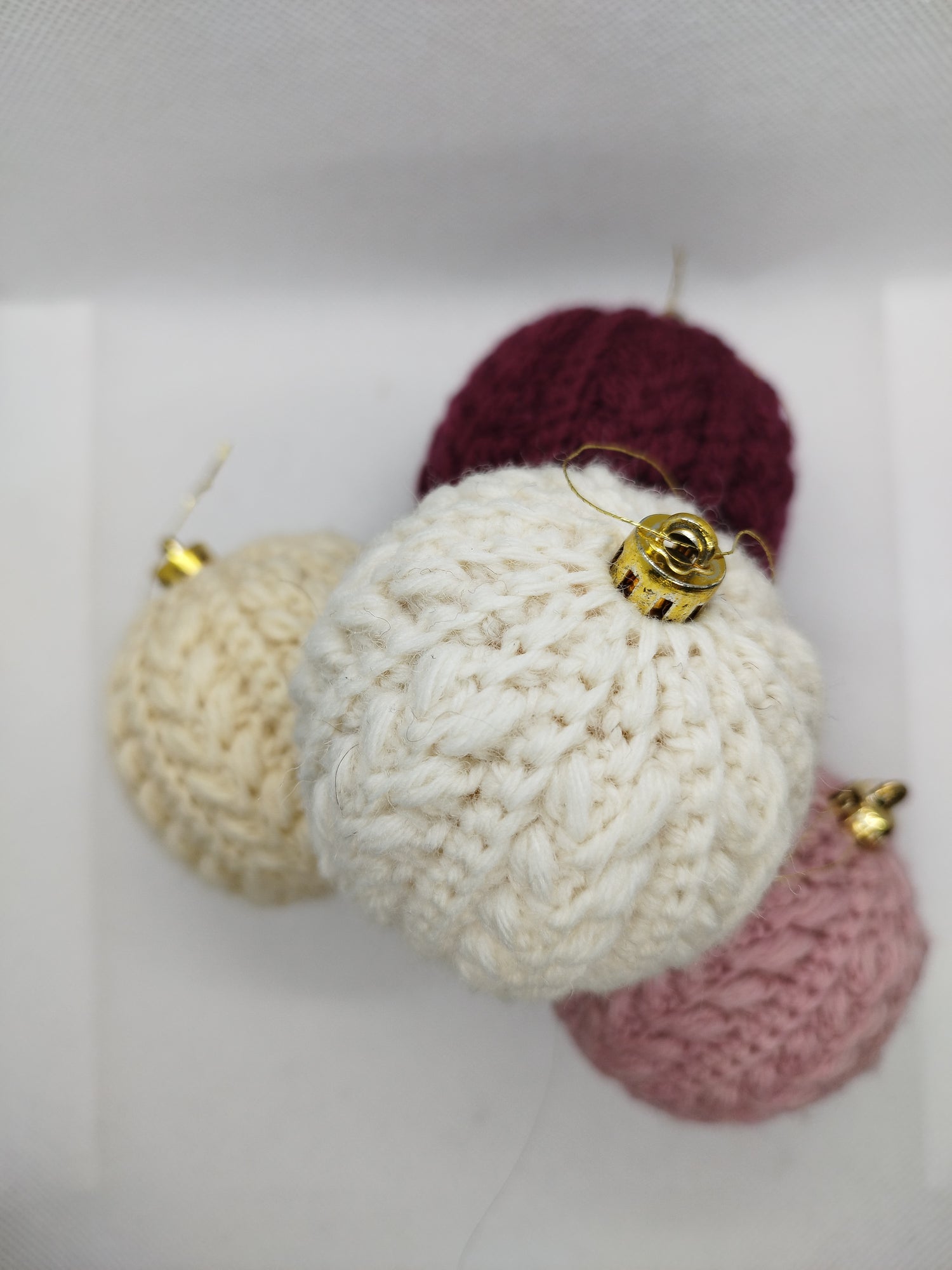 Set of handmade crochet Christmas ornaments in cream, burgundy and pink, soft festive decorations for Christmas tree