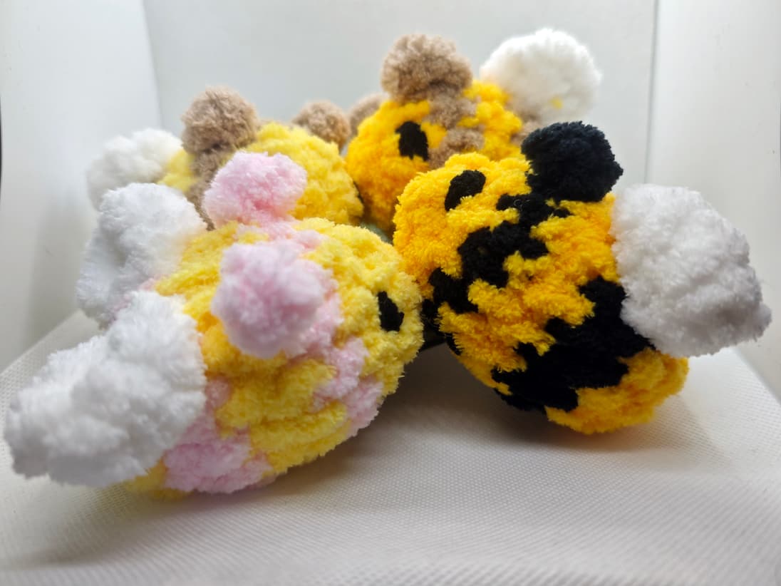 Handmade amigurumi bee plush toys in different colors grouped together