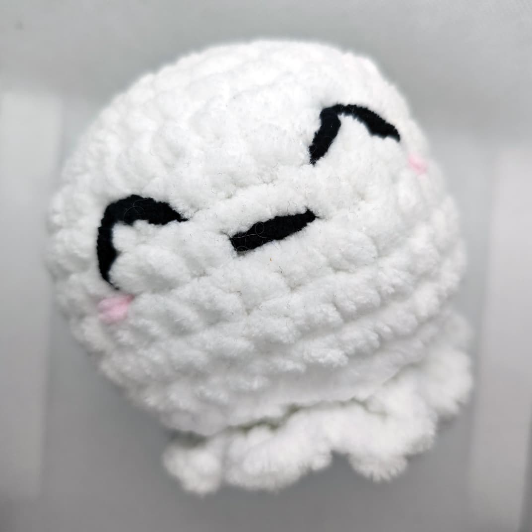 Soft white amigurumi ghost plush toy sitting upright