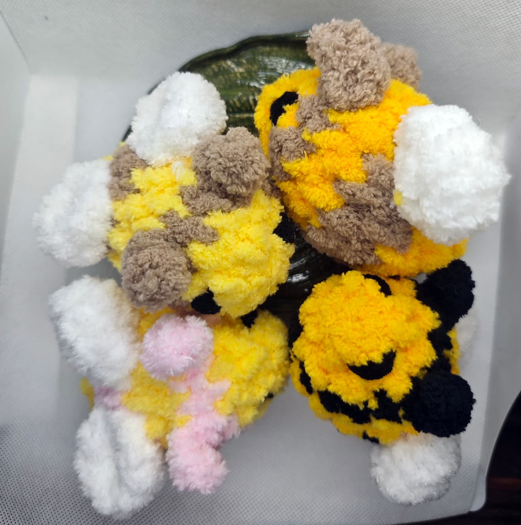 Set of handmade crochet bee plush toys in yellow and black with fluffy wings