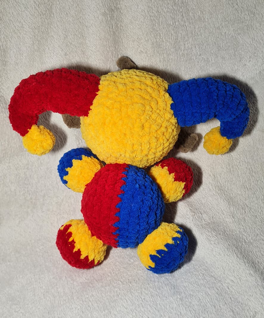 detail of handmade crochet clown plush amigurumi doll soft yarn texture