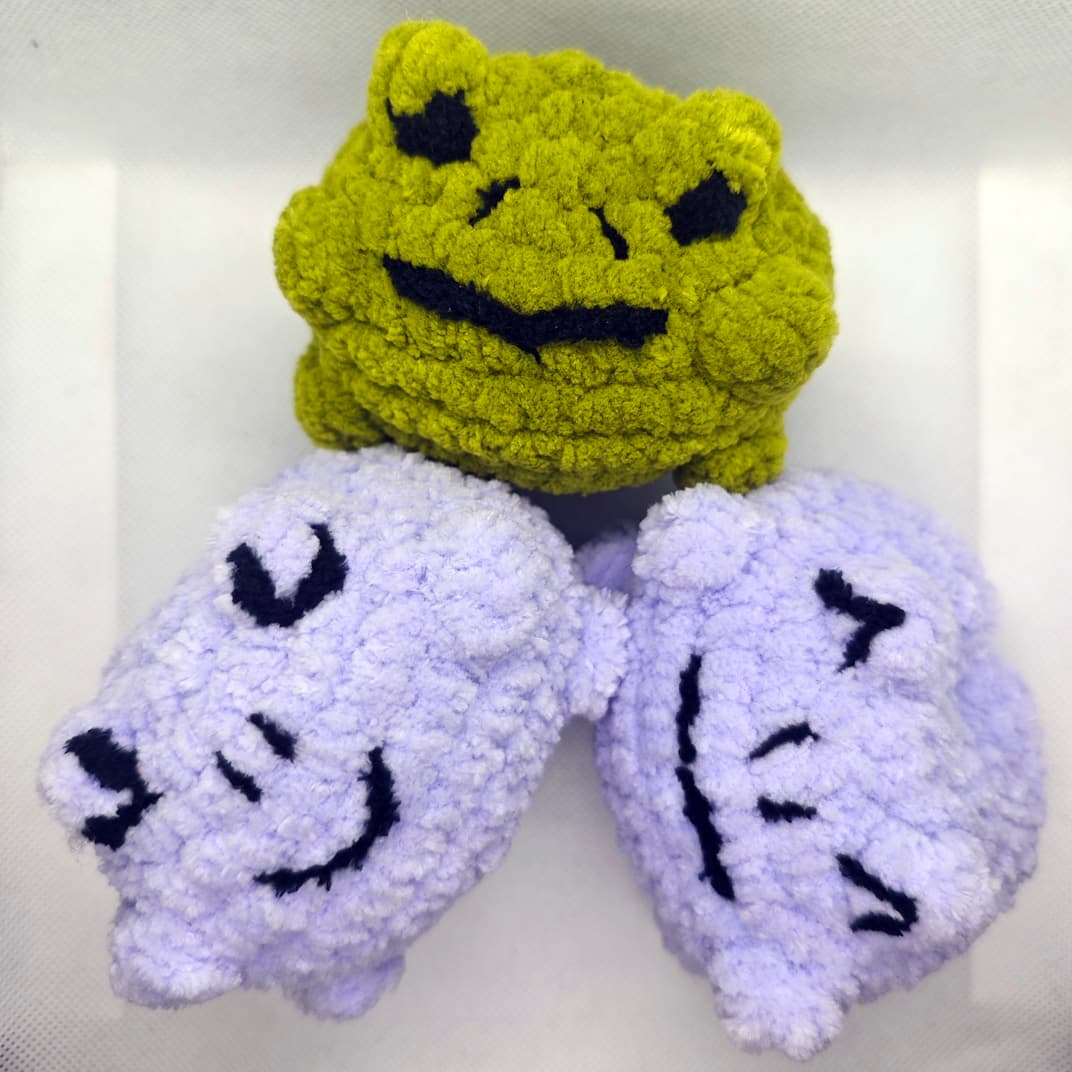 Handmade crochet frog and cat plush toys in green and purple colors