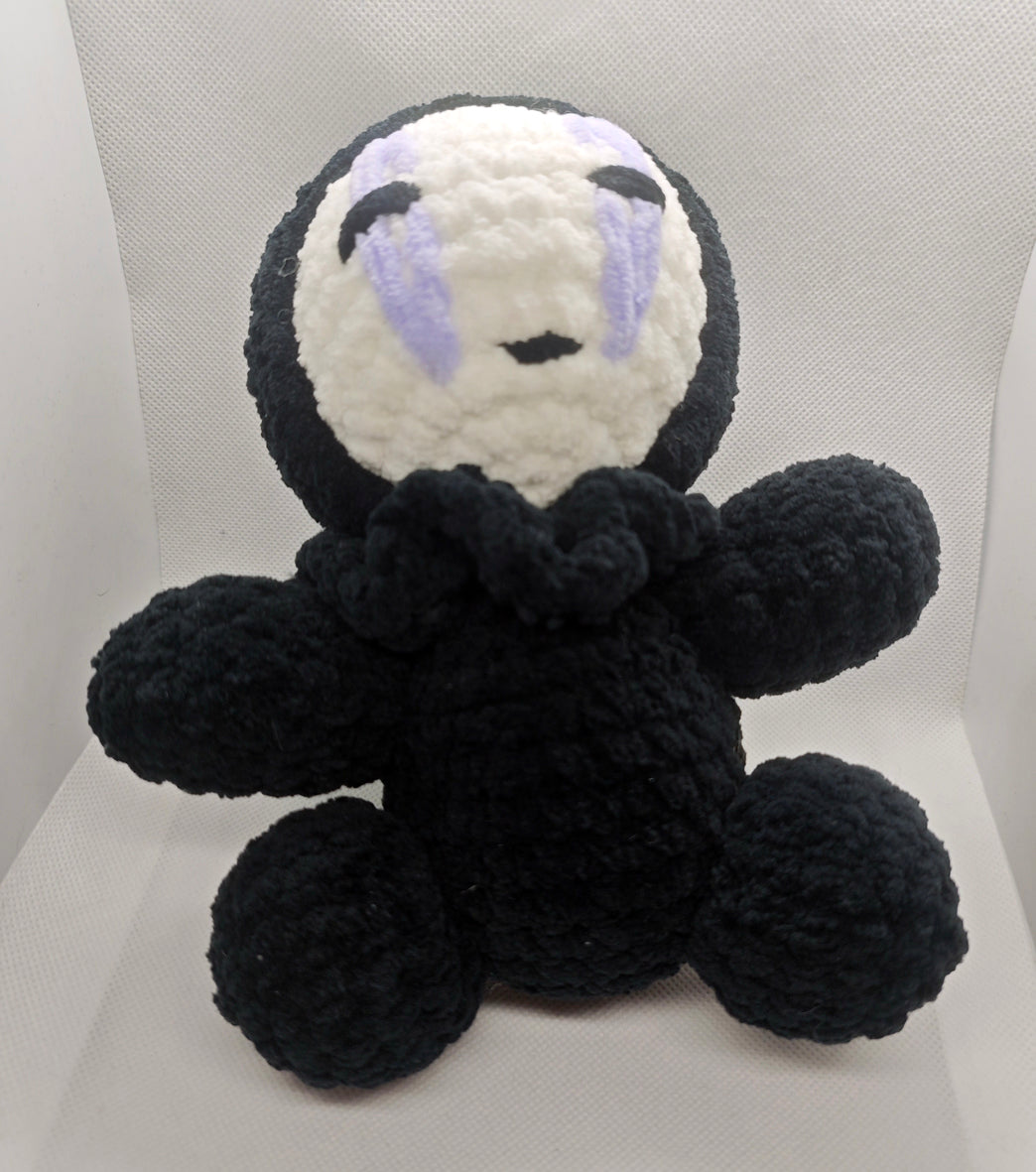 Handmade crochet No Face inspired plush toy close-up with embroidered facial details